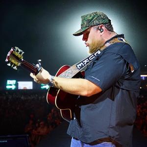 Luke Combs performing with a camo hat