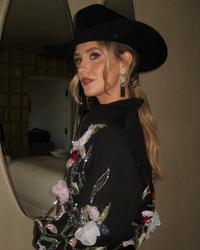 Lainey Wilson backstage wearing flowers