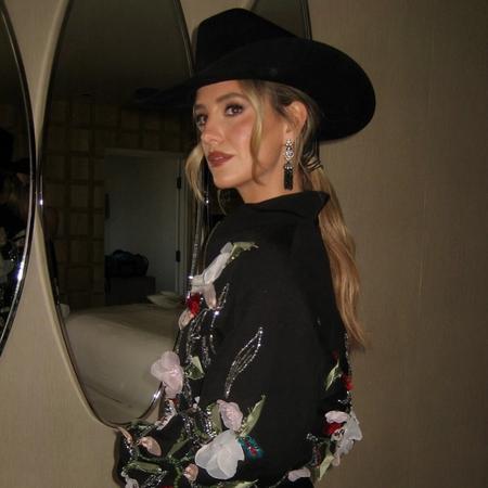 Lainey Wilson backstage wearing flowers