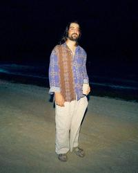 Noah Kahan stood on a beach