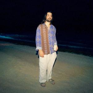 Noah Kahan stood on a beach