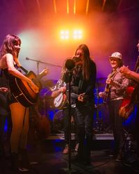 The Wood Brothers and Molly Tuttle surround a condenser microphone to perform.