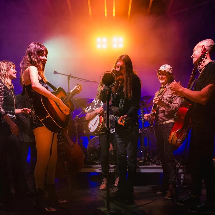 The Wood Brothers and Molly Tuttle surround a condenser microphone to perform.