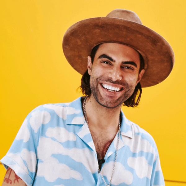 Niko Moon Smiling in front of a bright yellow background