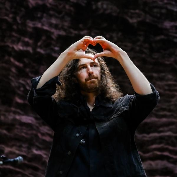 Hozier holding his hands in a love heart shape