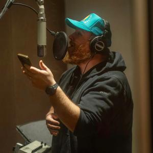 Luke Combs in the studio with a blue hat on