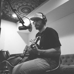 Chase Rice recording in a studio with a guitar