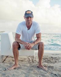 Kenny Chesney sat on a blue chair on the beach