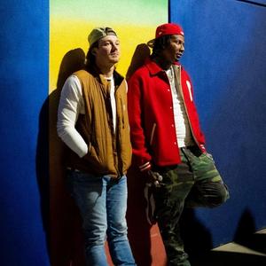 Moneybagg Yo and Morgan Wallen leaning against a brightly coloured wall