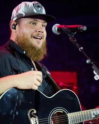 Luke Combs performing with a Raiders hat on