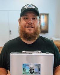 Luke Combs holding a briefcase