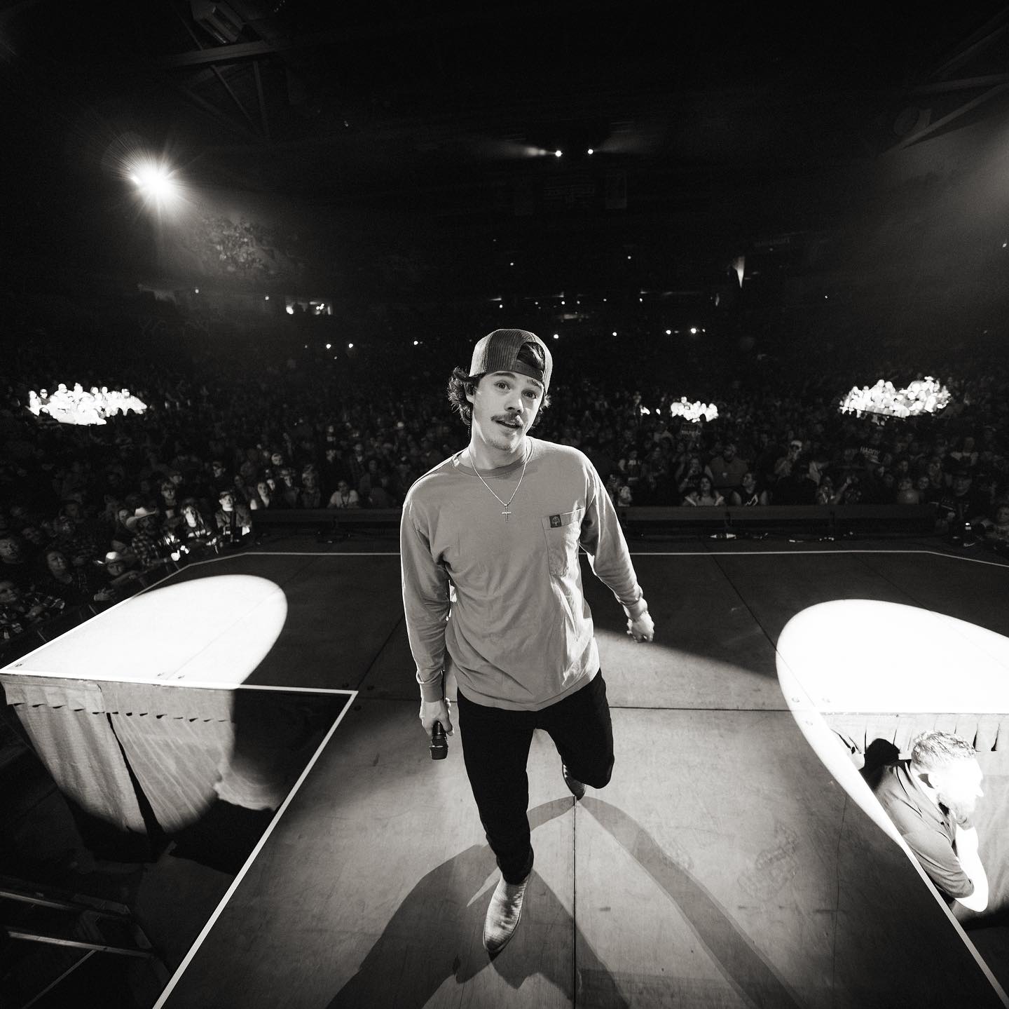 <p>Dylan Marlowe smiling at the camera while performing live on tour in black and white</p>