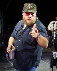 Luke Combs wearing a camo hat backstage