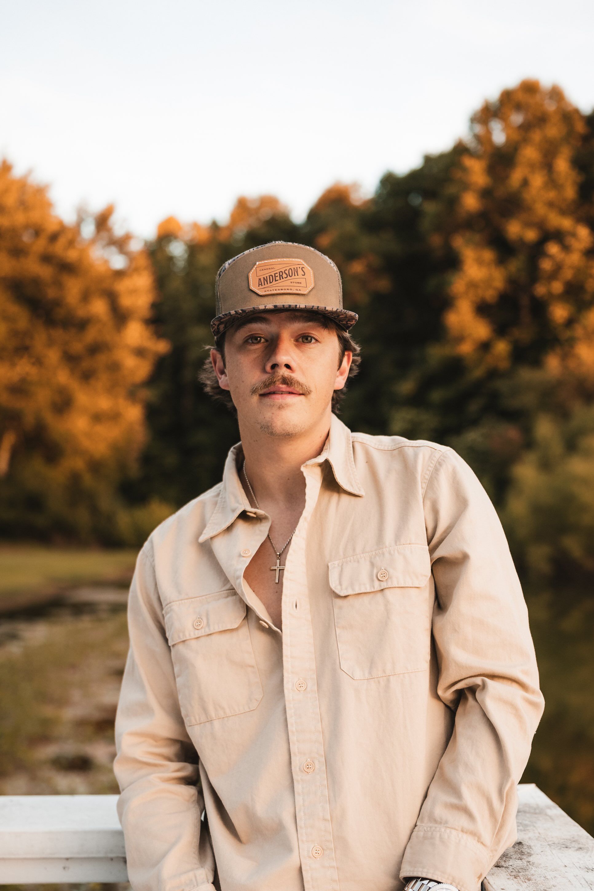 Dylan Marlowe standing in the sunset in front of some trees