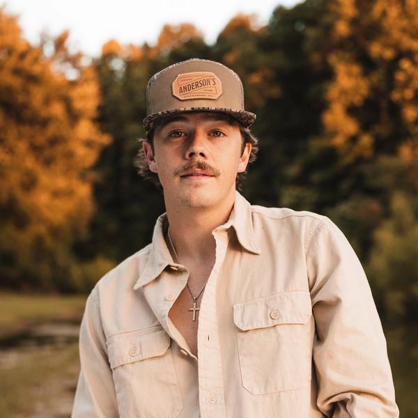 Dylan Marlowe standing in the sunset in front of some trees