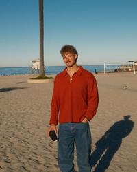 Forrest Frank holding coffee on the beach