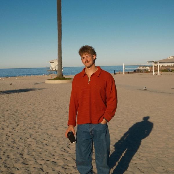 Forrest Frank holding coffee on the beach