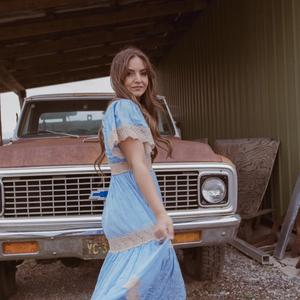 Brit Taylor in a dress in front of a truck