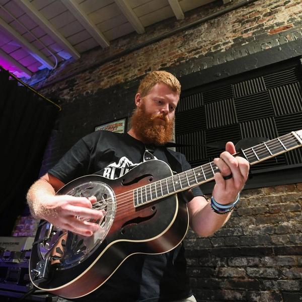 Oliver Anthony playing guitar in an old church 