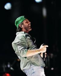 Thomas Rhett performing in a green hat