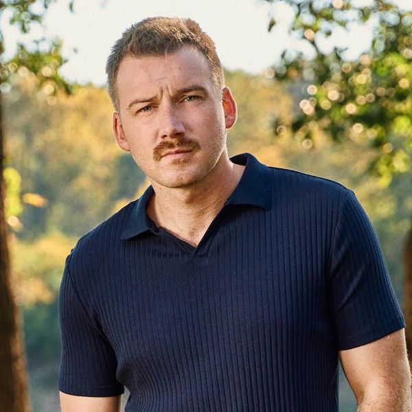 Morgan Wallen with short hair looking into the camera in the woods