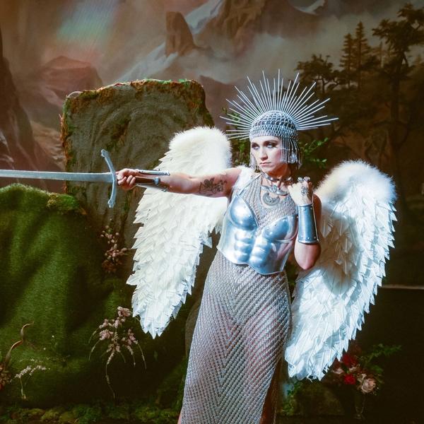 Sierra Ferrell wielding a sword while wearing wings