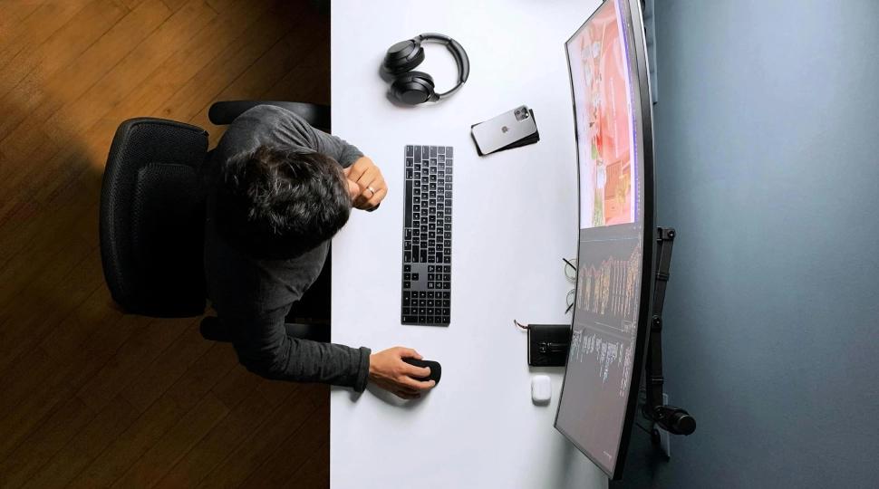 Top view of someone working at a desk in front of a monitor