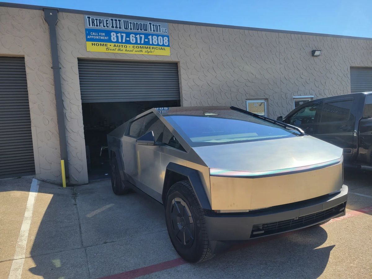 Silver angular pickup with newly tinted windows outside the Triple III shop