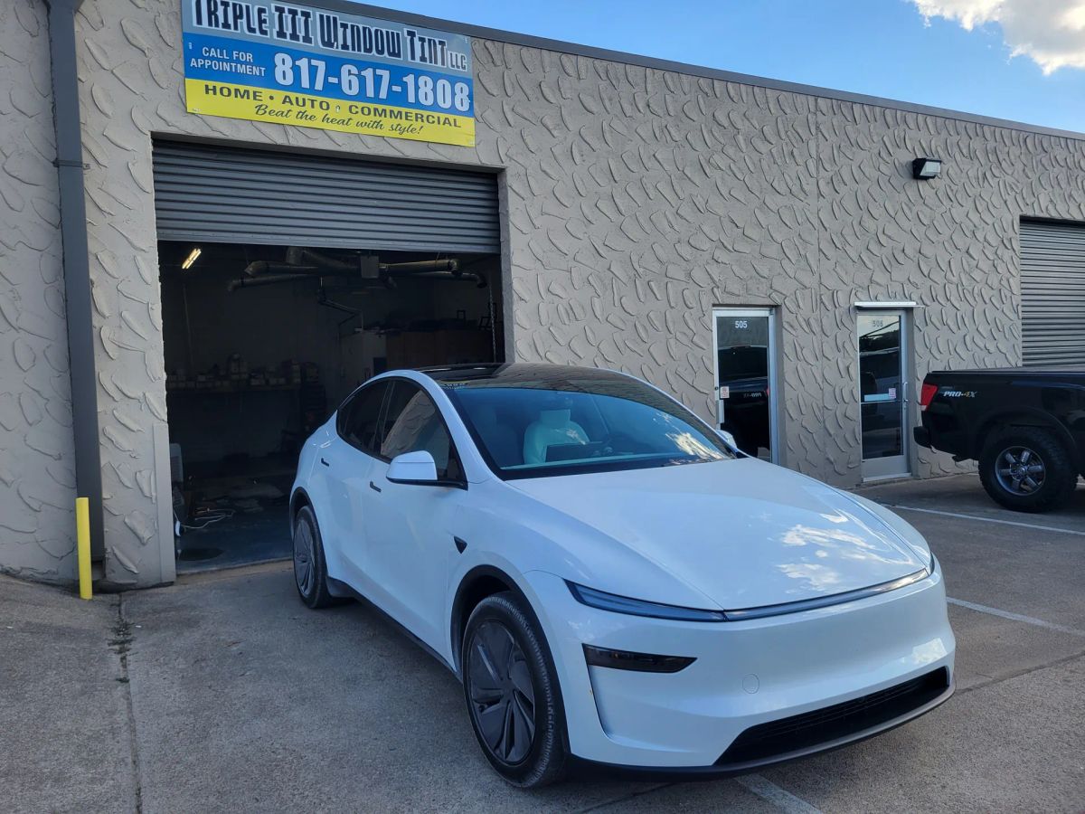 White Tesla crossover with newly tinted windows outside the Triple III shop
