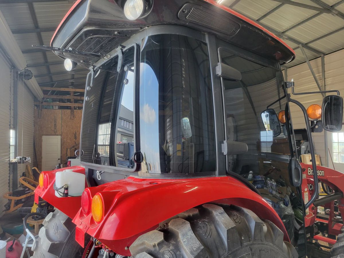 Red tractor cab with professionally tinted curved glass