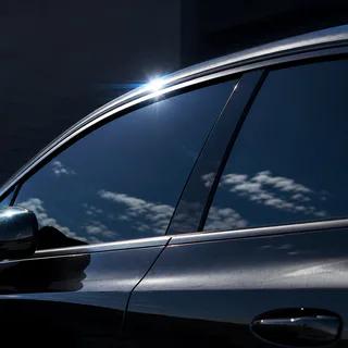 Dark ceramic-tinted vehicle windows reflecting bright sunlight