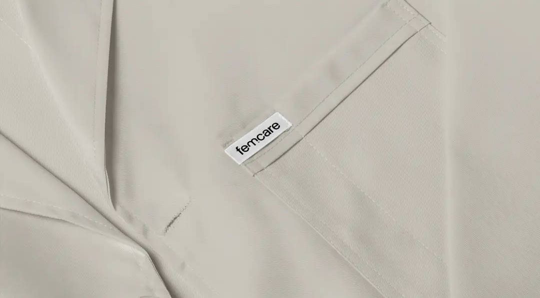 Close-up of light beige fabric with a white tag reading "femcare".