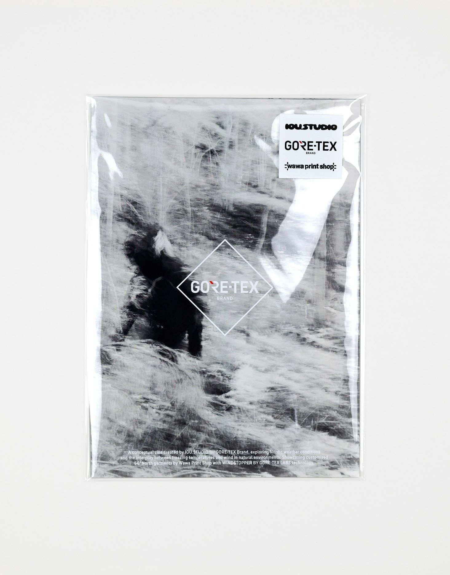 Shrink-wrapped collaboration zine created by IOU.STUDIO for GORE-TEX Brand, cover showing a blurred figure in a snowy Nordic landscape and a GORE-TEX, Wawa Print Shop, IOU.STUDIO sticker