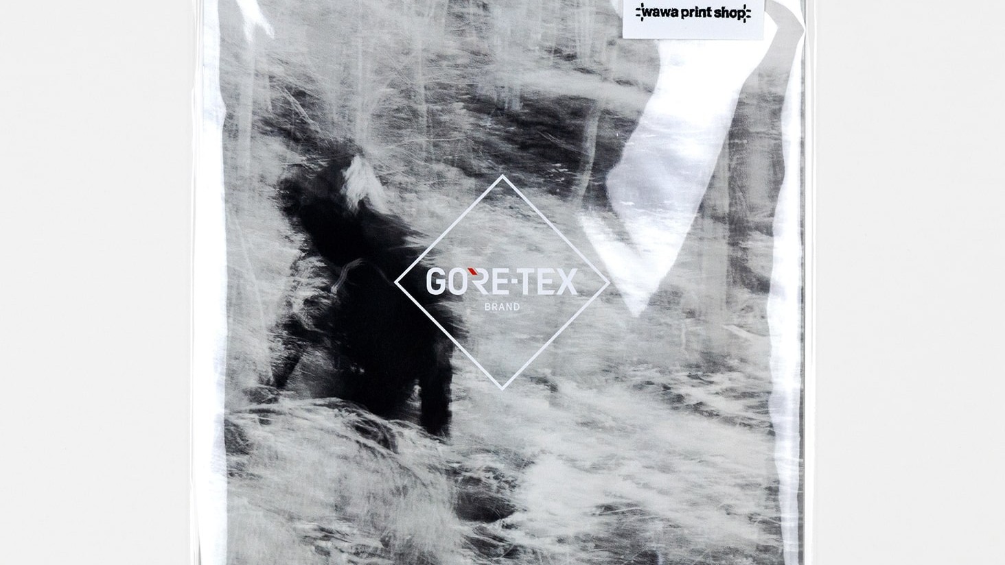 Shrink-wrapped collaboration zine created by IOU.STUDIO for GORE-TEX Brand, cover showing a blurred figure in a snowy Nordic landscape and a GORE-TEX, Wawa Print Shop, IOU.STUDIO sticker