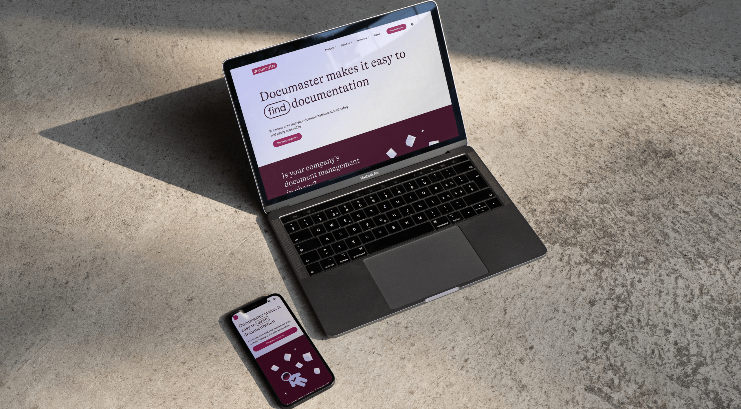 A MacBook and iPhone showing the redesigned Documaster website, including its wordplay headline about finding documentation.
