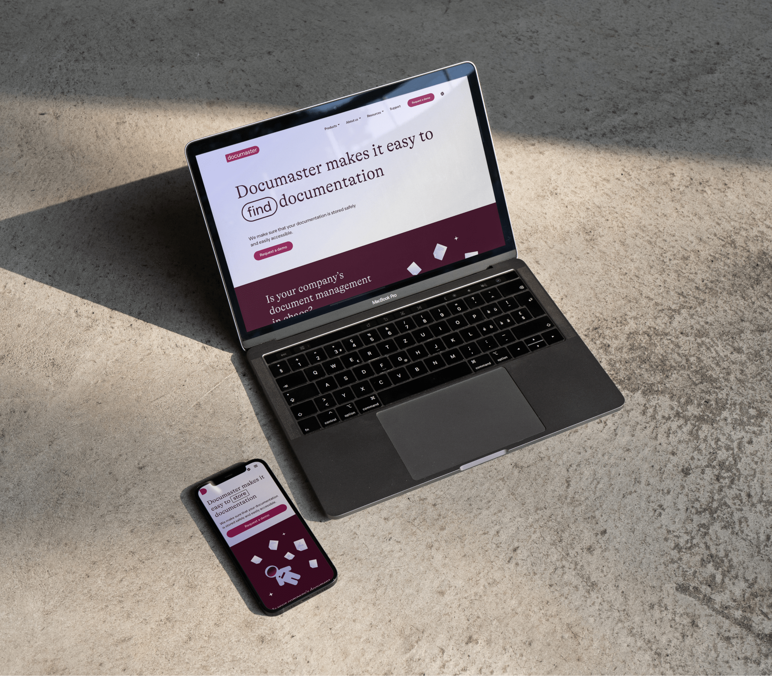 A MacBook and iPhone showing the redesigned Documaster website, including its wordplay headline about finding documentation.