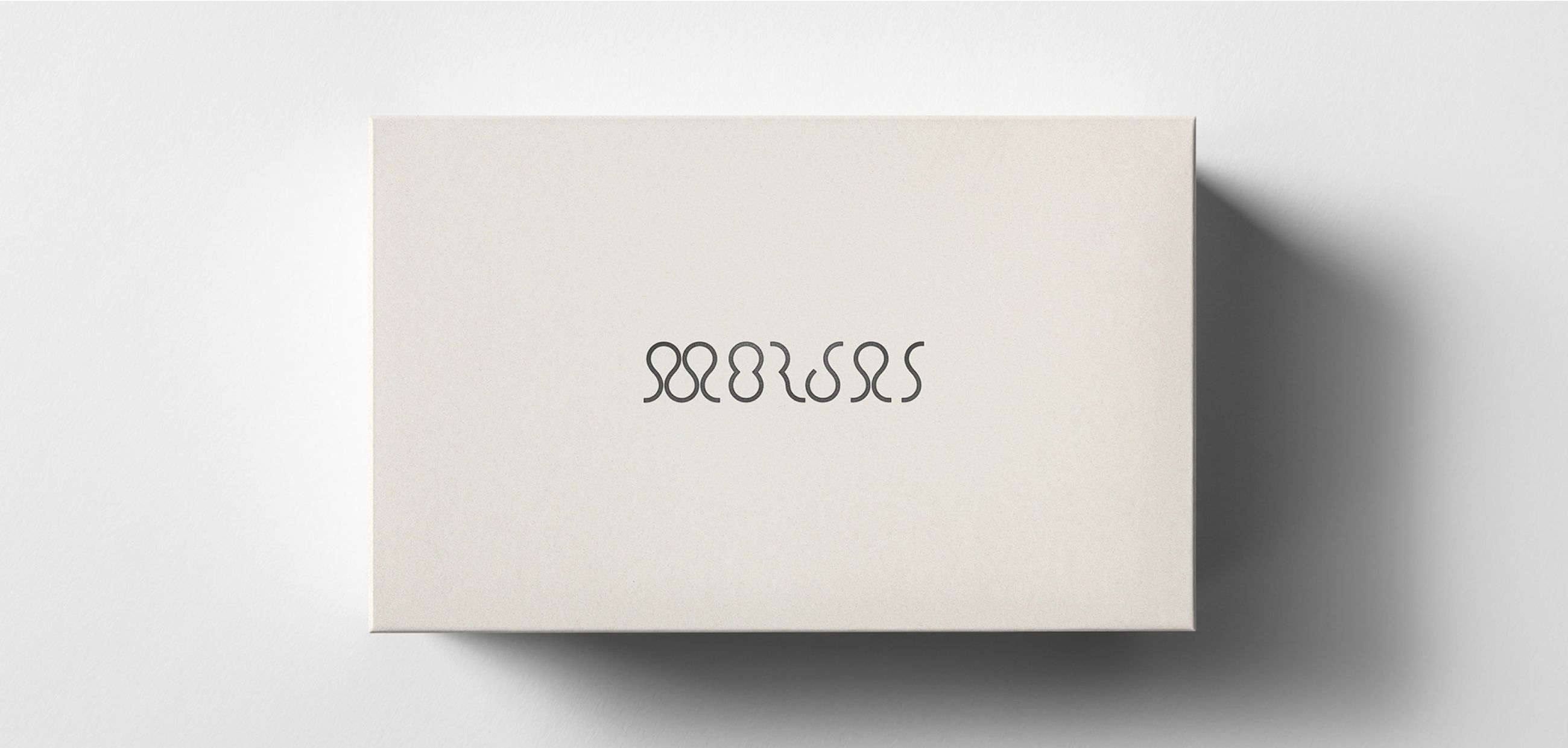 Light beige box with "MORJAS" in a black looped font.