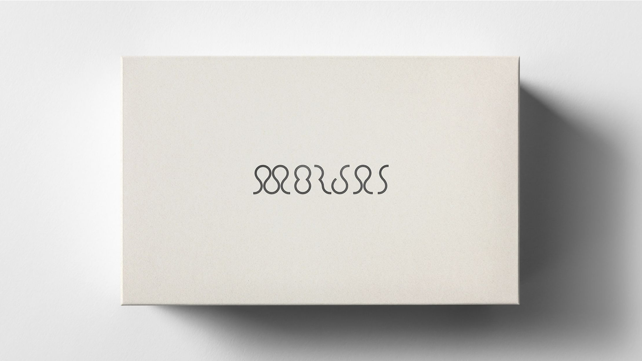 Light beige box with "MORJAS" in a black looped font.