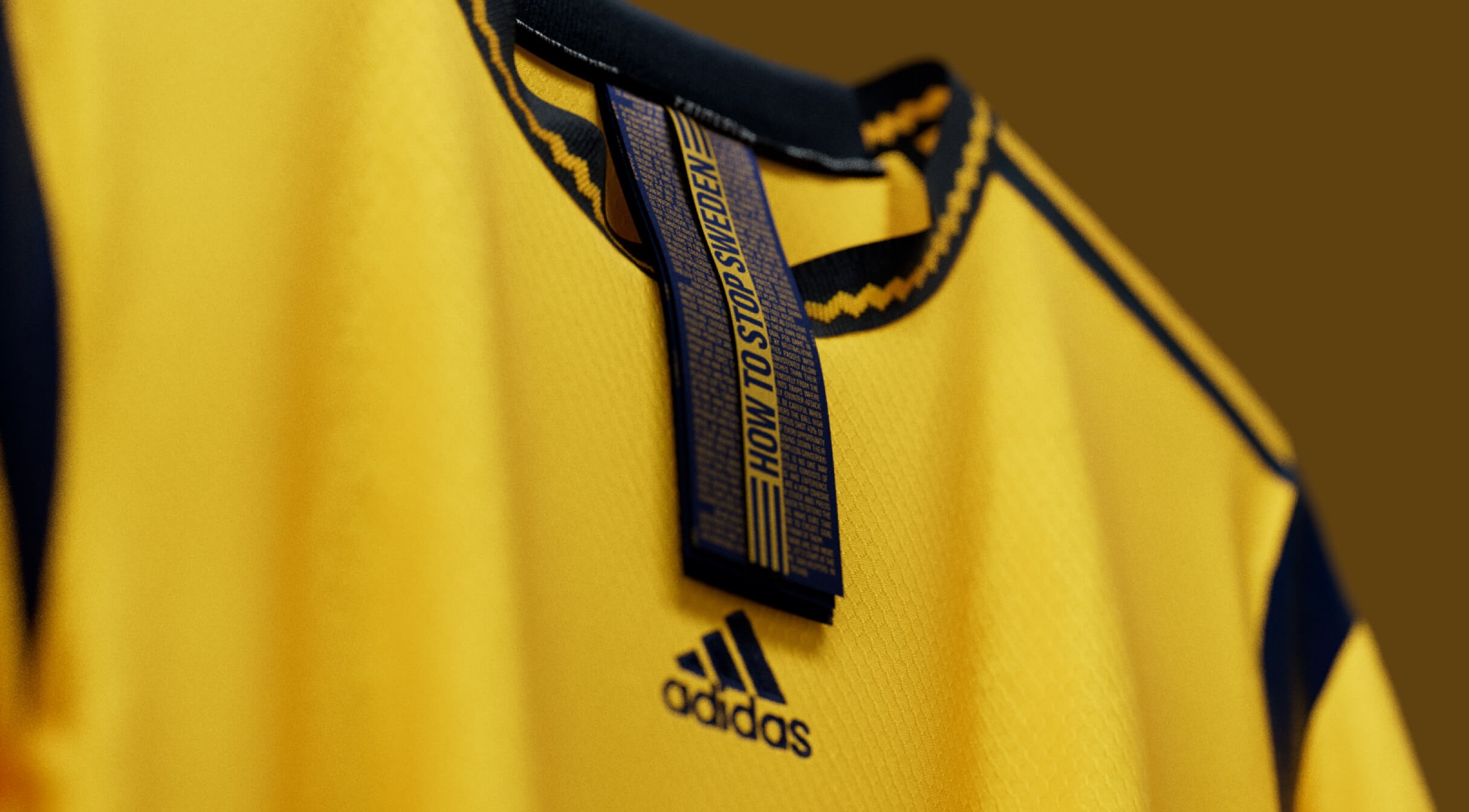 Close-up of a Sweden women's national team jersey collar tag printed "HOW TO STOP SWEDEN" in small guide-style text, with the adidas mark below.