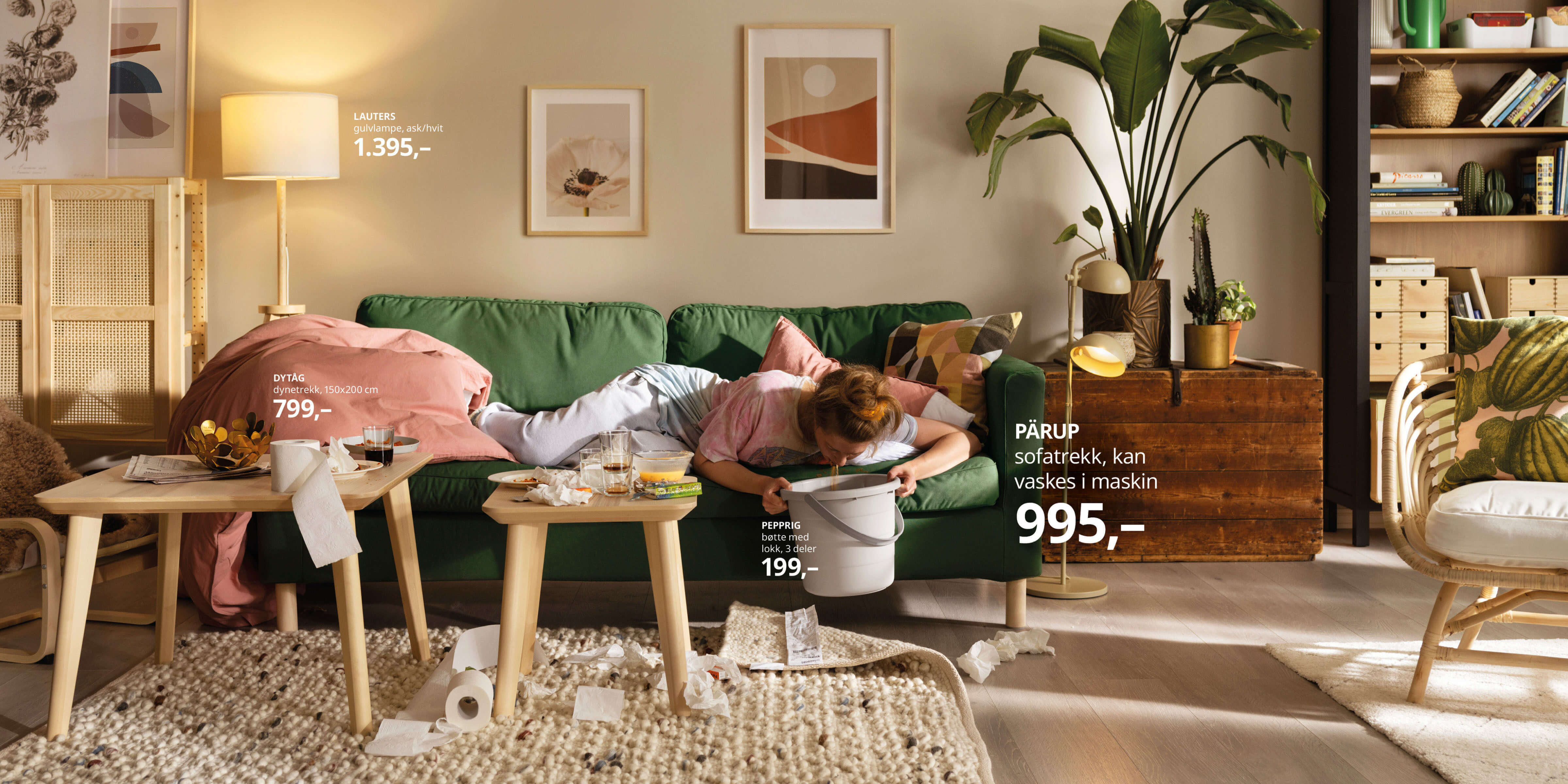 Dame som ligger og spyr på sofaen i en stue bestående av kun IKEA-møbler, med prislapper på møblene rundt henne.
