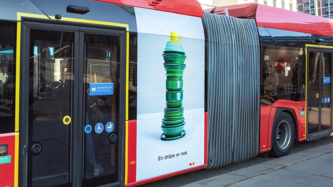 Zalo-kampanjens tallerkenstabel i flaskeform påført siden av en buss.