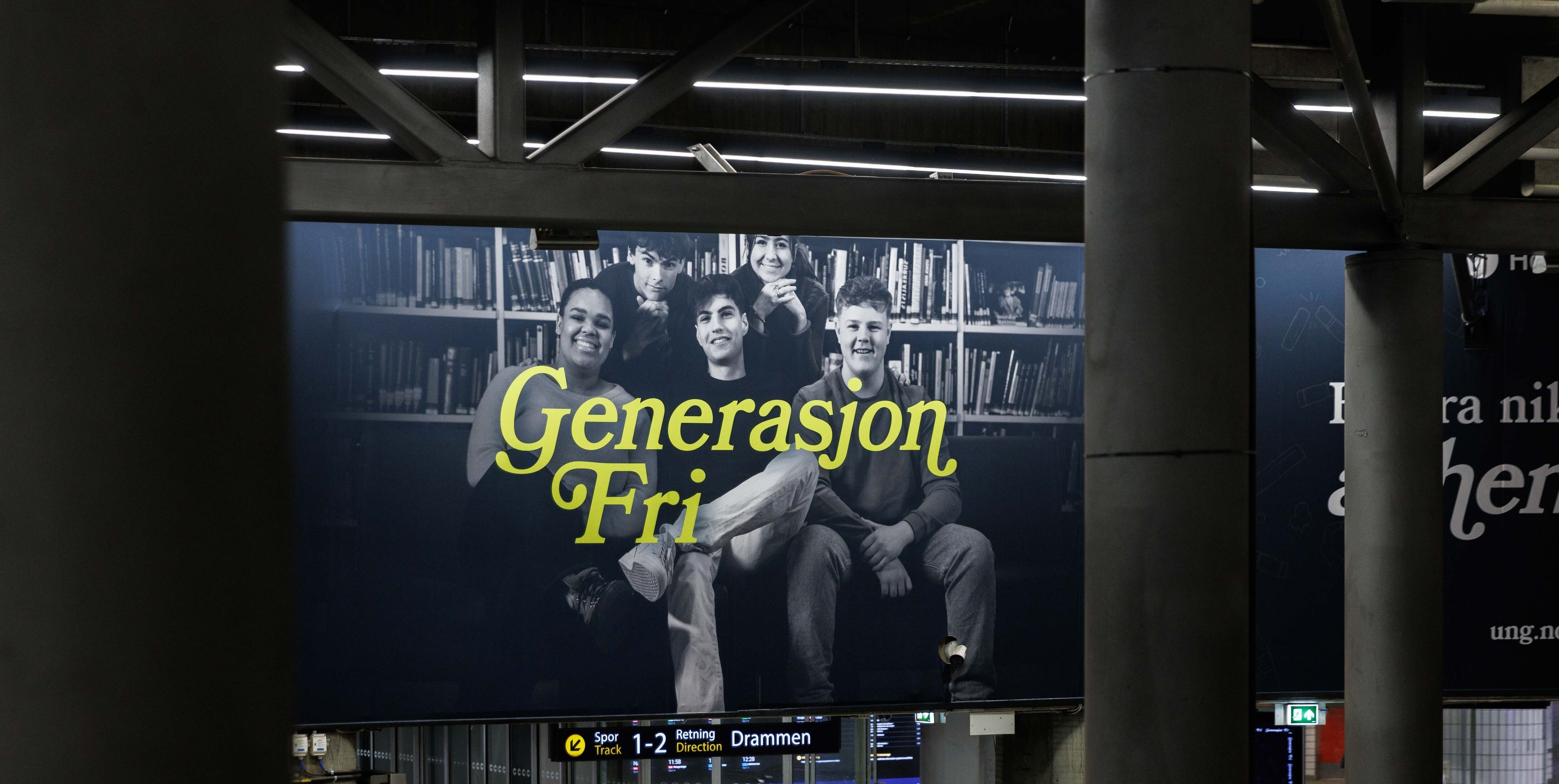 A large billboard shows four smiling young people in grayscale with yellow text "Generasjon Fri" against bookshelves, framed by dark pillars.