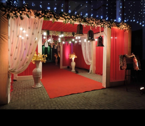 Decorated entrance with drapes, florals and red carpet