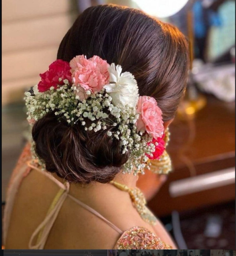 Bridal hair dressed with carnations and baby's breath