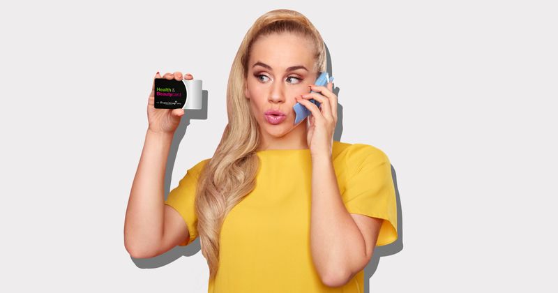 Women on her mobile holding a Superdrug Health & Beauty card.
