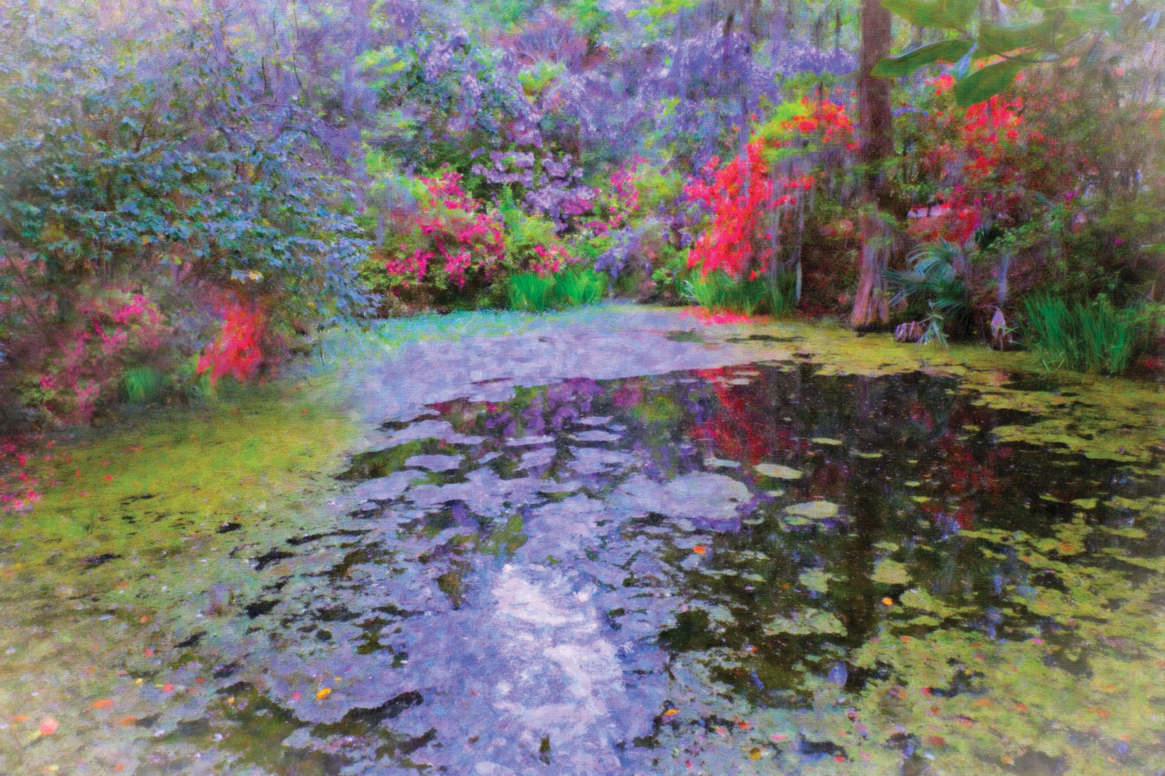 A lily pond painted in loose impressionist strokes, its banks massed with pink, red and violet blossom reflected in the water.