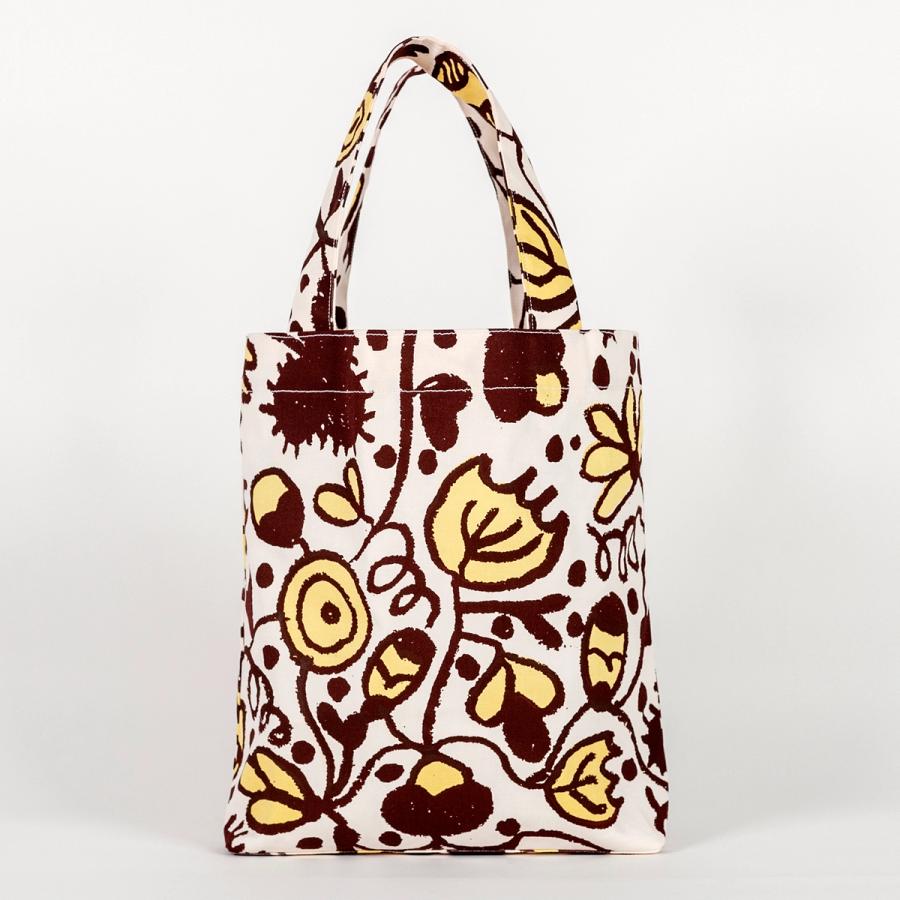 A tall, rectangular tote bag made of fabric yardage consisting of brown and yellow floral motifs.