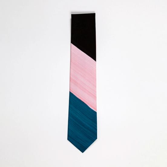 A photo of the bottom half of a folded tie. The tie features three diagonal bands of black, peach, and blue-green.