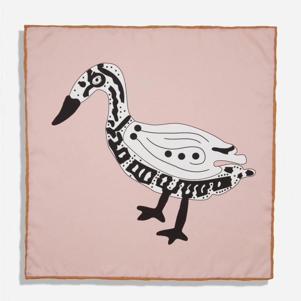 A rose pink silk pocket square with a printed bold black and white illustration of a Bata bird. There is a warm, dark tan bordered seam.