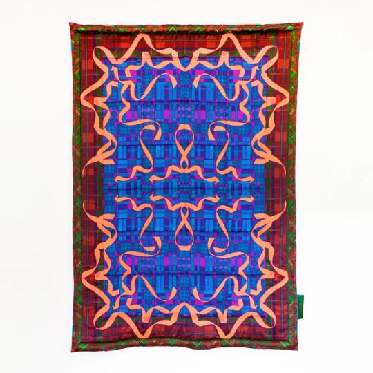 A rectangular blanket with a dark red border and deep blue center. A mirrored pattern of bright red ribbons make up the top layer of detail.